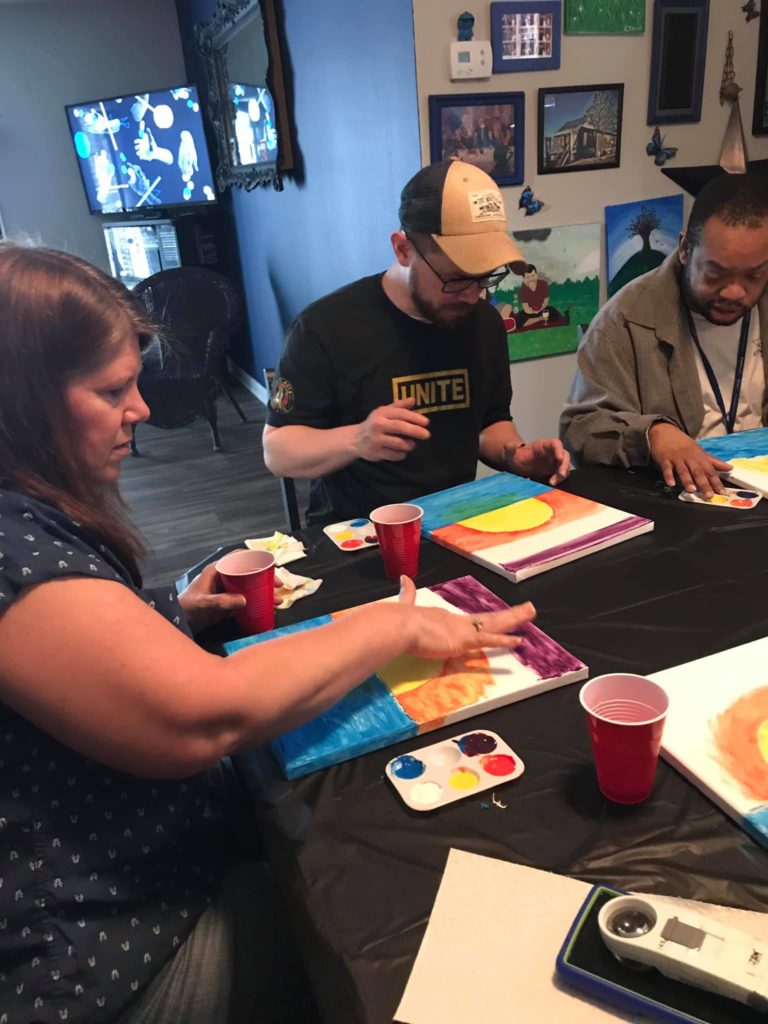 people sitting at table fingerpainting