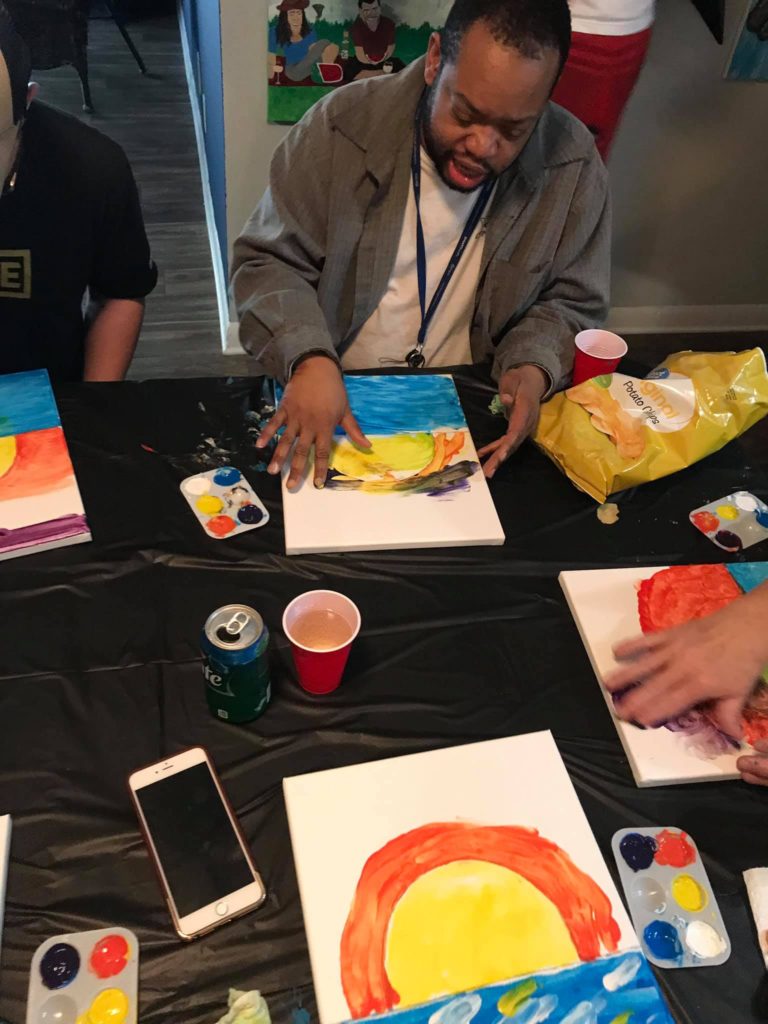 more people sitting at table finger painting